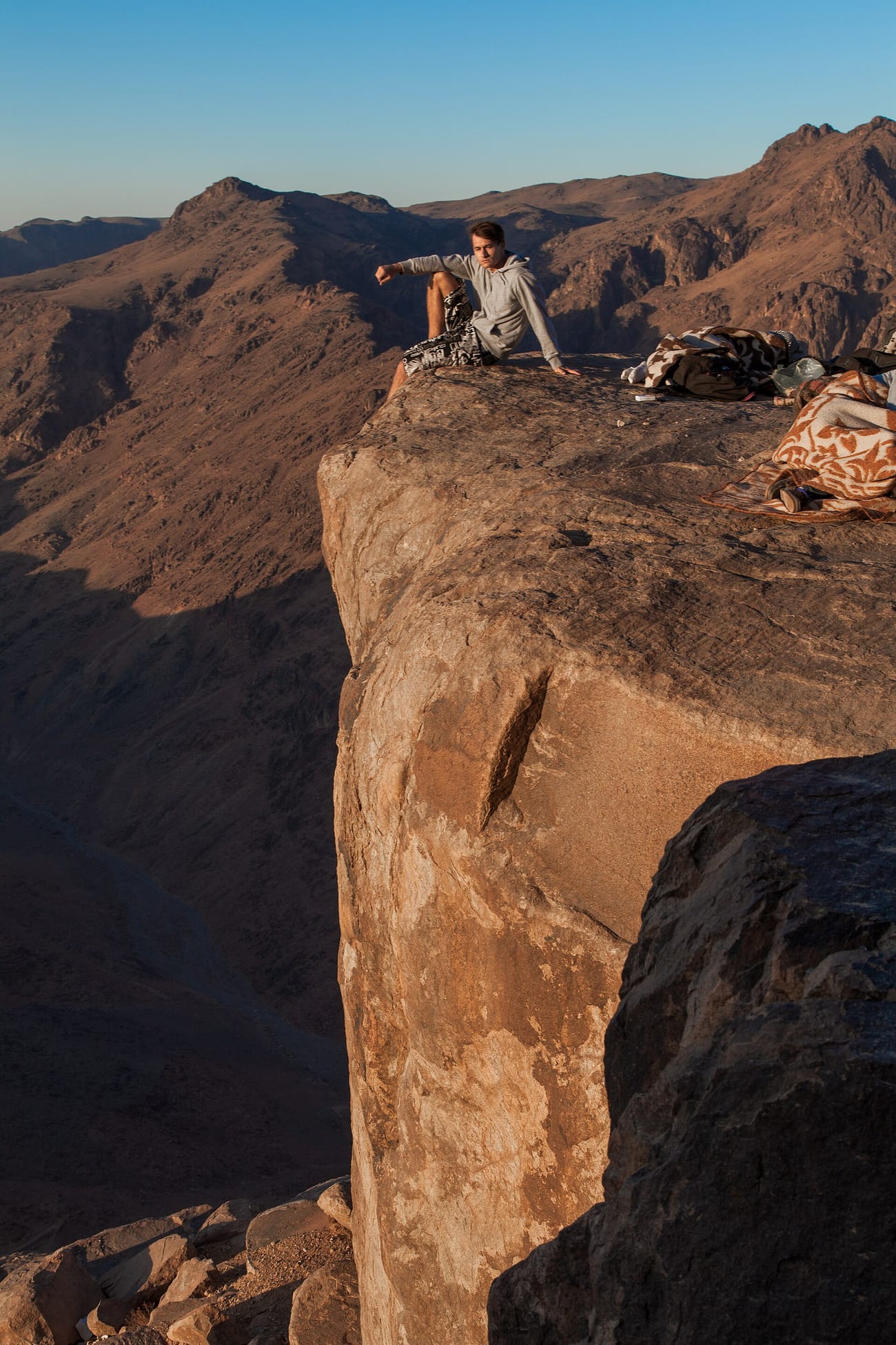 Sunrise over the rocky summit of Mount Sinai with hikers and the chapel near the top in Egypt